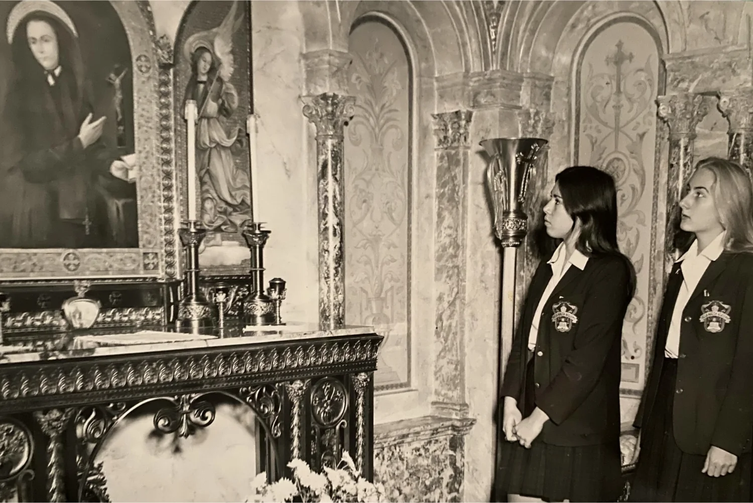 black and white photo of students looking at a painting